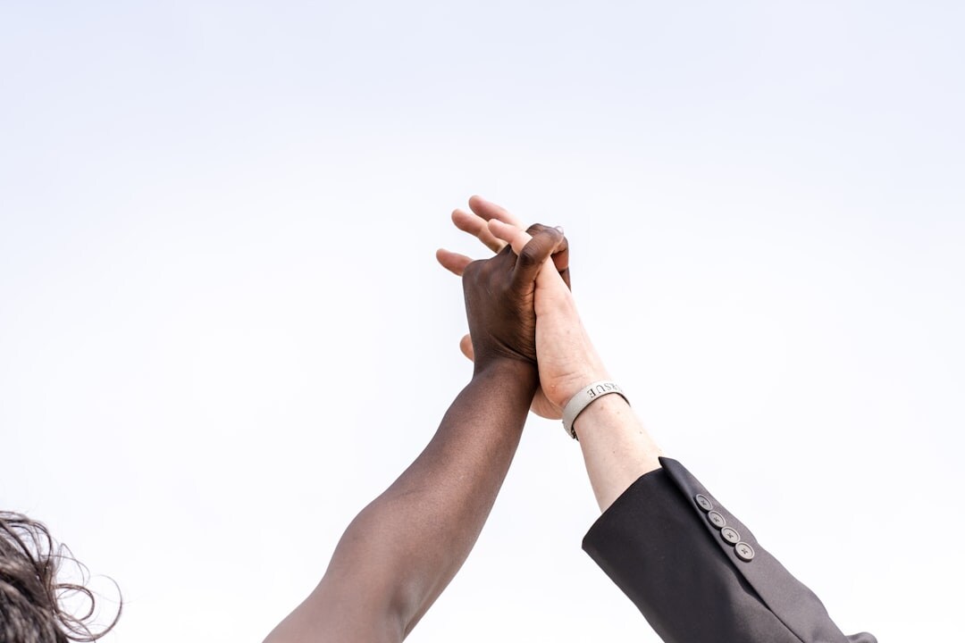 Diverse business team celebrating success with raised hands outdoors