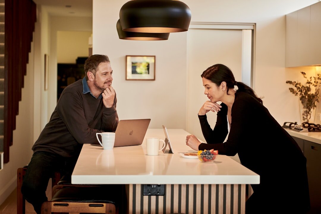 Team of colleagues discussing around a table with laptops