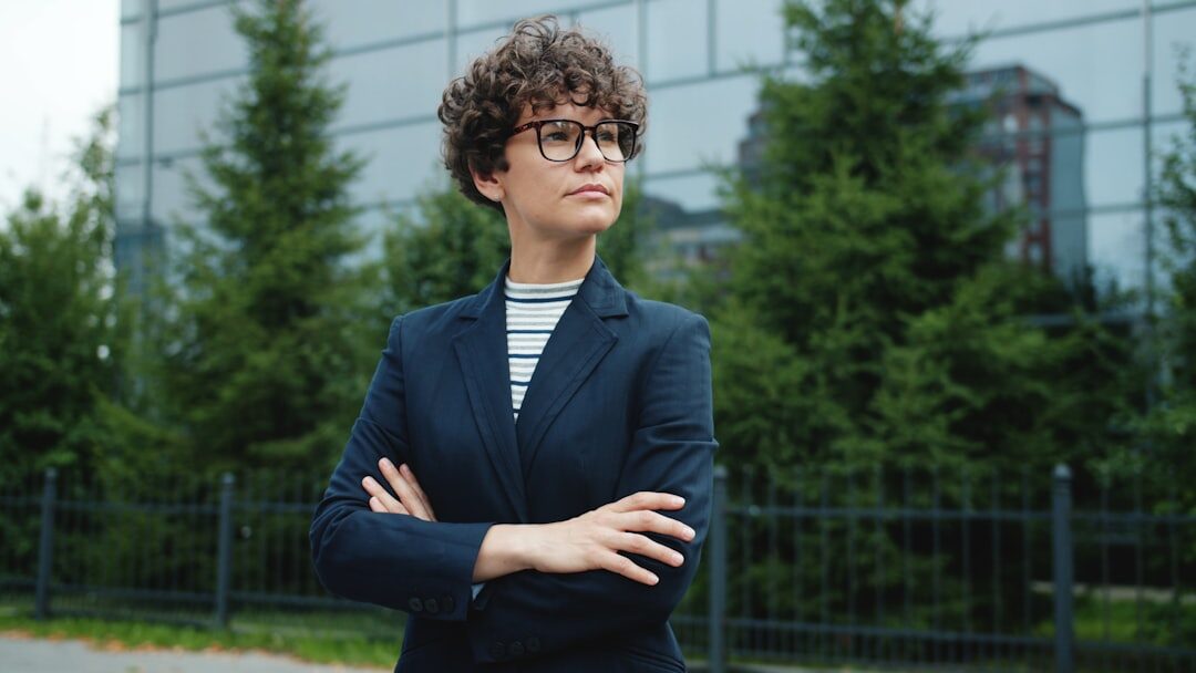 Confident Belgian businesswoman standing with arms crossed in a modern office