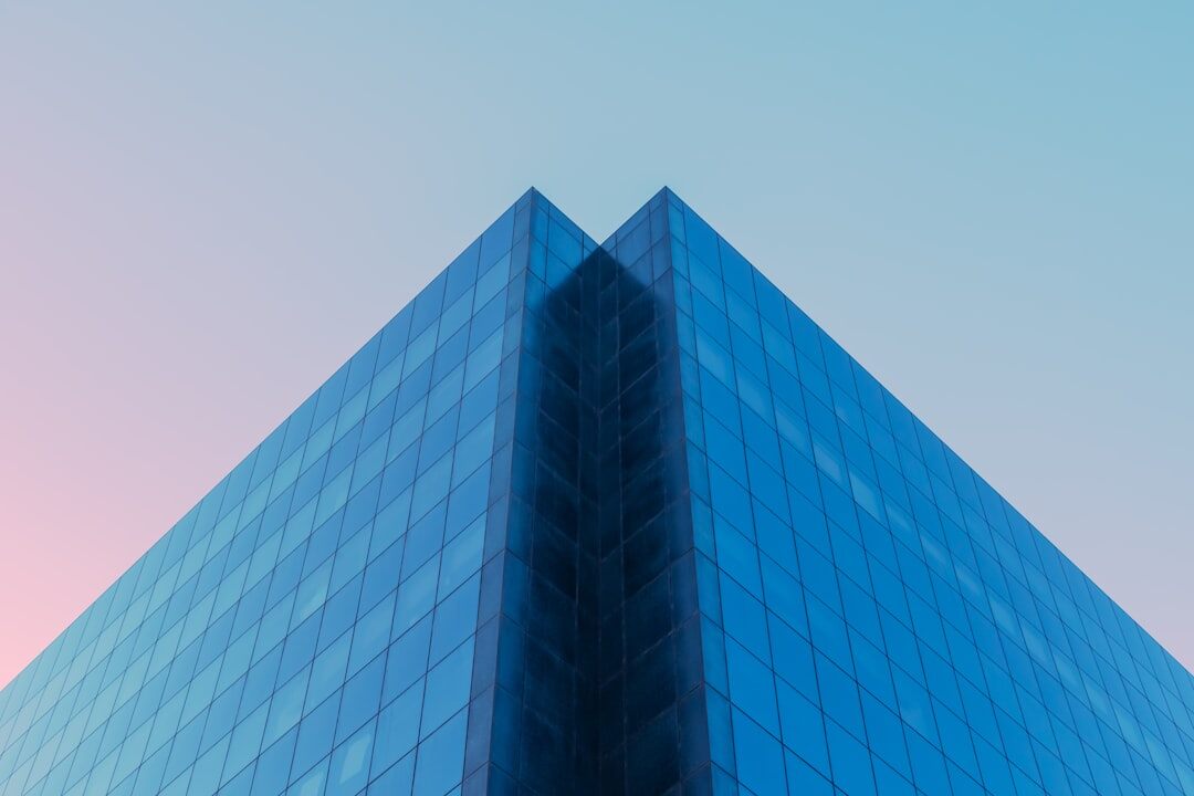 Modern glass office building facade under a clear sky